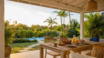 Terrasse de location de vacances au Lamentin avec table de petit-déjeuner et jardin tropical.